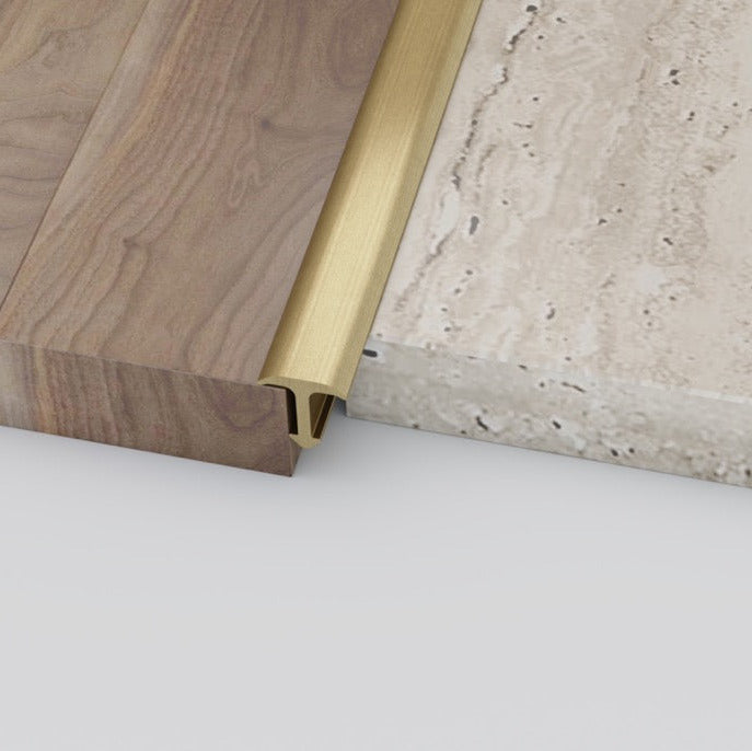 Close-up of a wooden surface with a brass strip and a concrete floor.